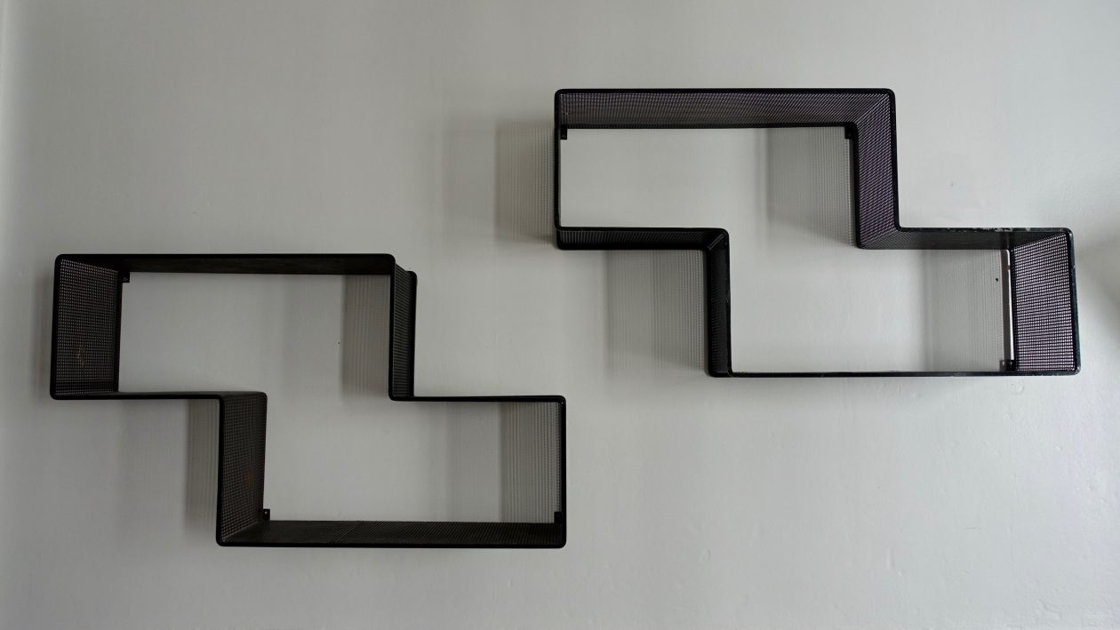 Étagères « Dedal » en métal laqué noir de Mathieu Matégot, vers 1955. Quelques traces. H: 50cm x L: 89cm x l: 19,5cm